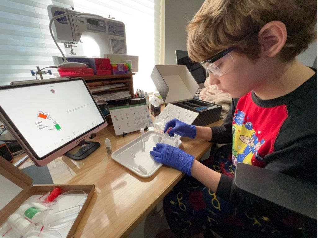 kids using a tablet to follow along using a Mel Science Kit