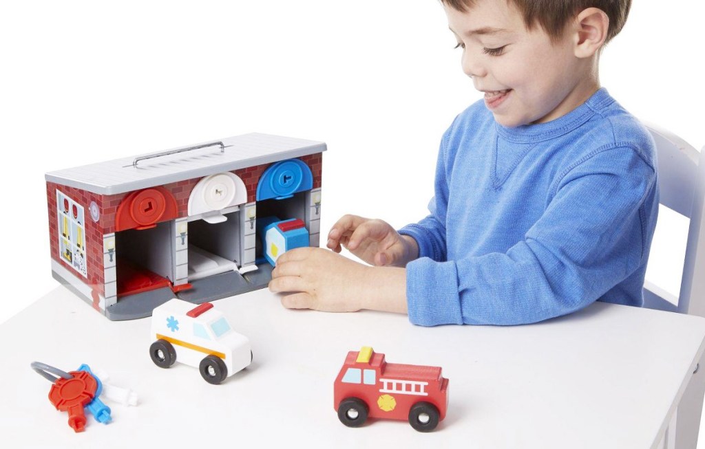 boy playing with Melissa & Doug Keys & Cars Rescue Garage set