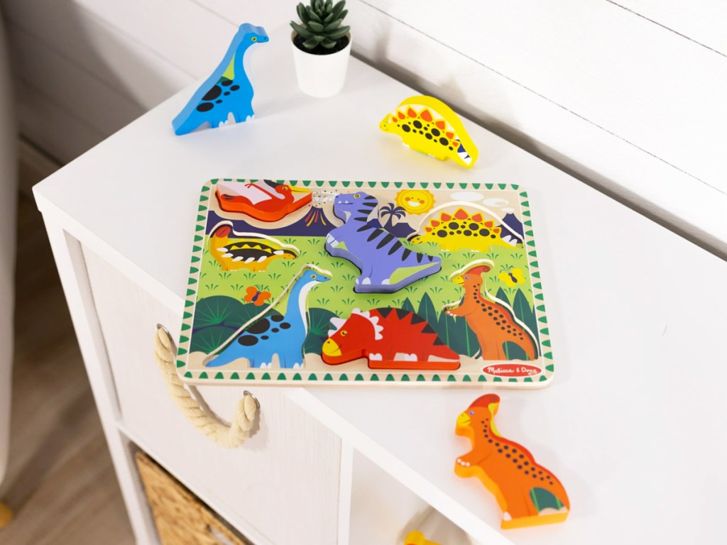 dinosaur puzzle on top of white bookcase