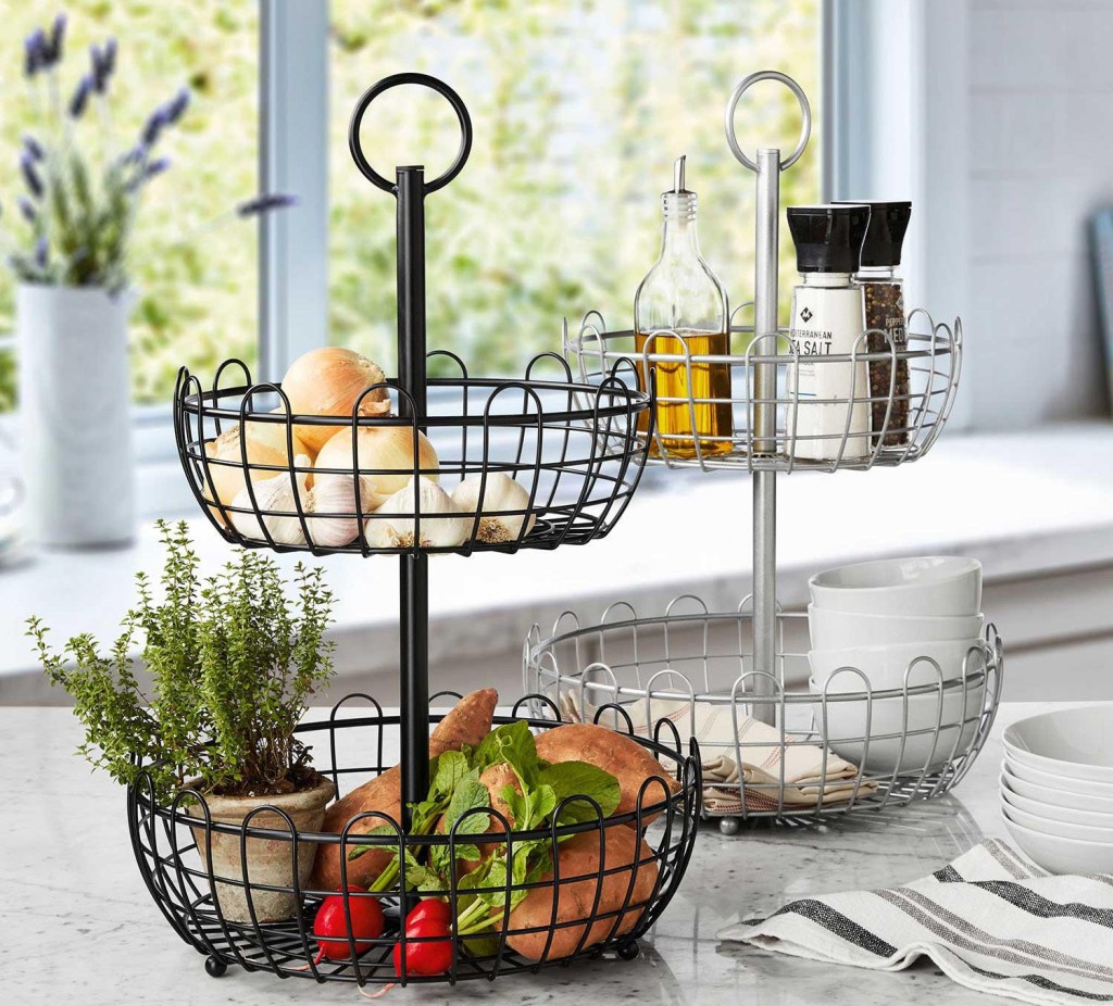 Two wire baskets on a counter with food and kitchen supplies in them