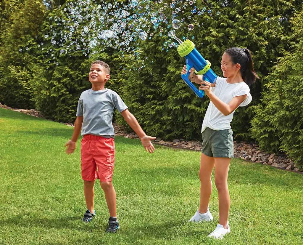 two kids playing with a large bubble blaster