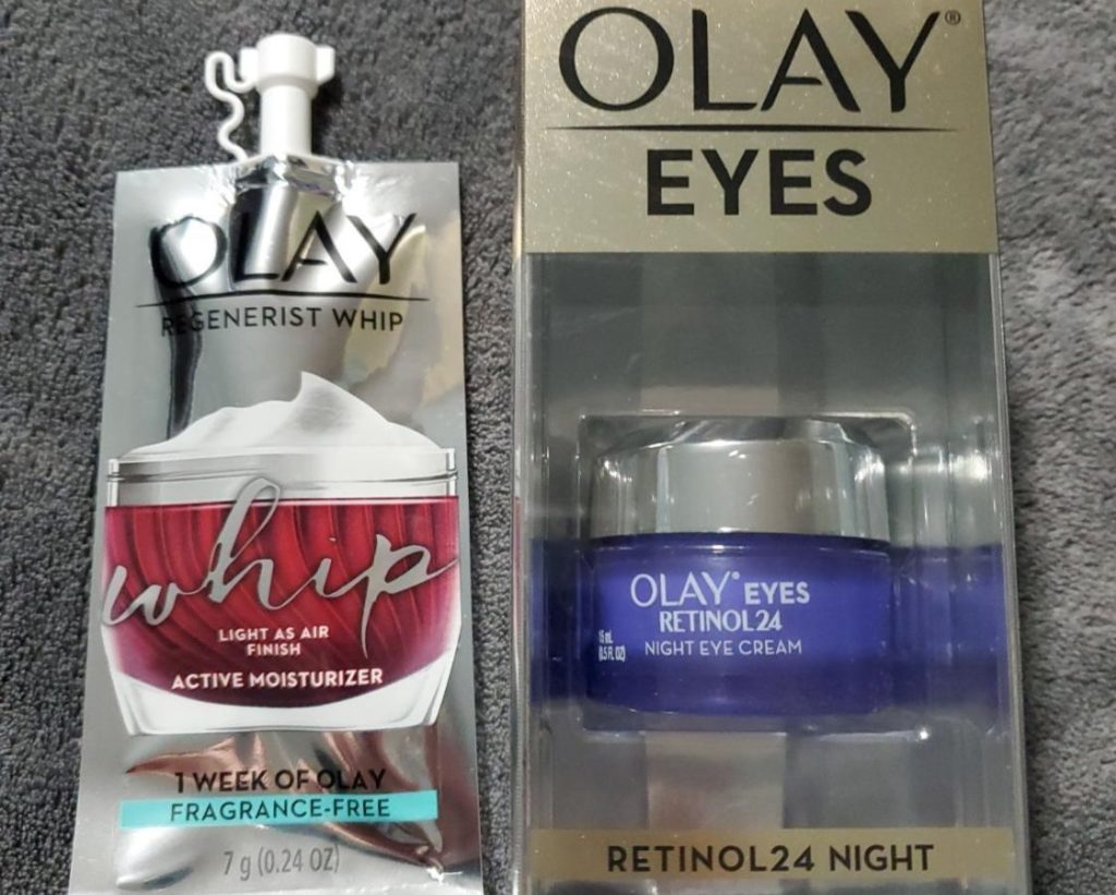 Olay Eyes Retinol 24 Cream in box next to sample size pouch of Olay Whip Facial Moisturizer