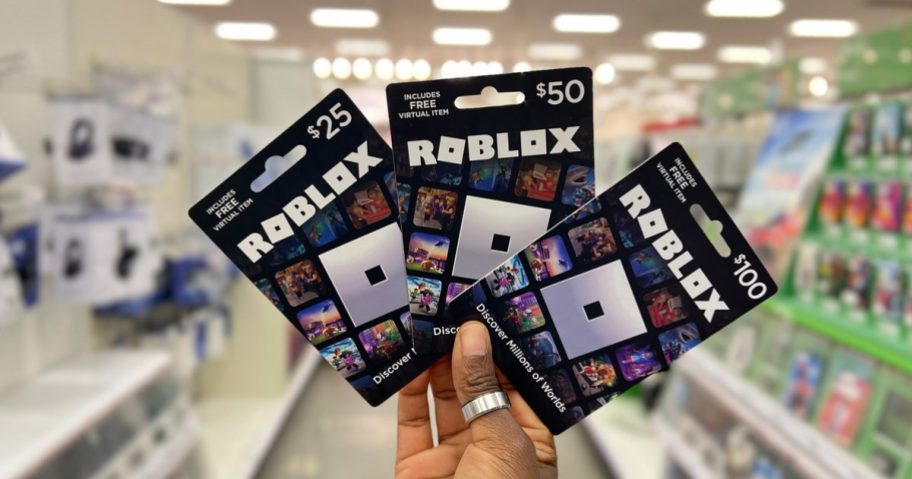 hand holding three Roblox Gift Cards at Target