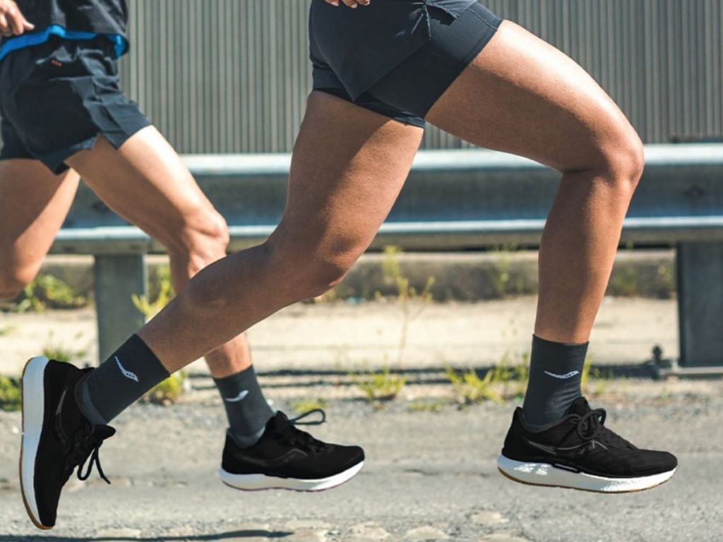 men running and wearing Saucony black Triumph 19 Shoes