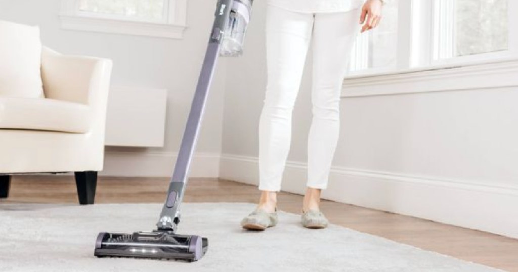 woman vacuuming white carpet
