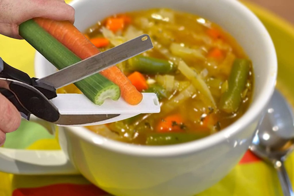 Hand cutting vegetables for soup using a scissor, knife, cutting board combo