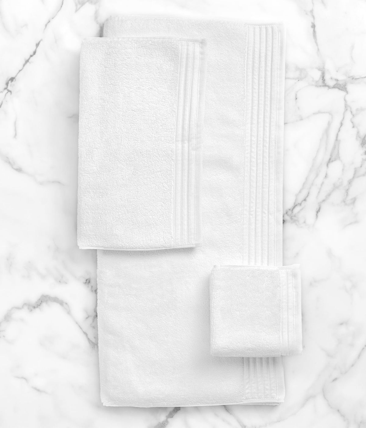 White hotel towels on a marble counter