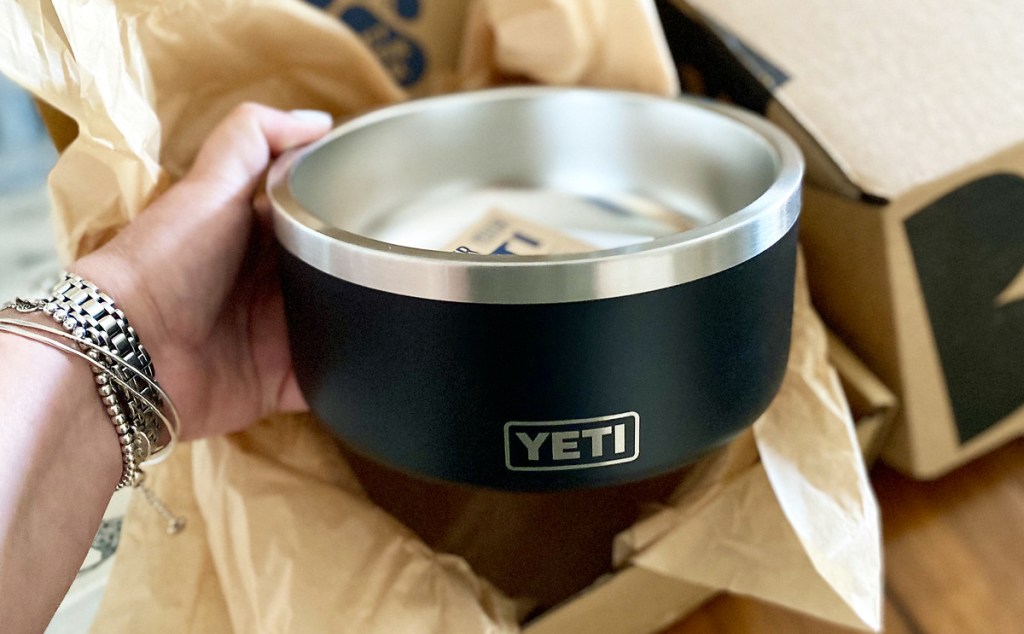 holding black yeti dog bowl