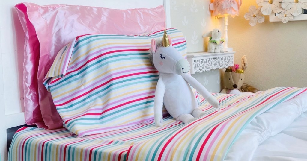 white bed with rainbow striped sheets