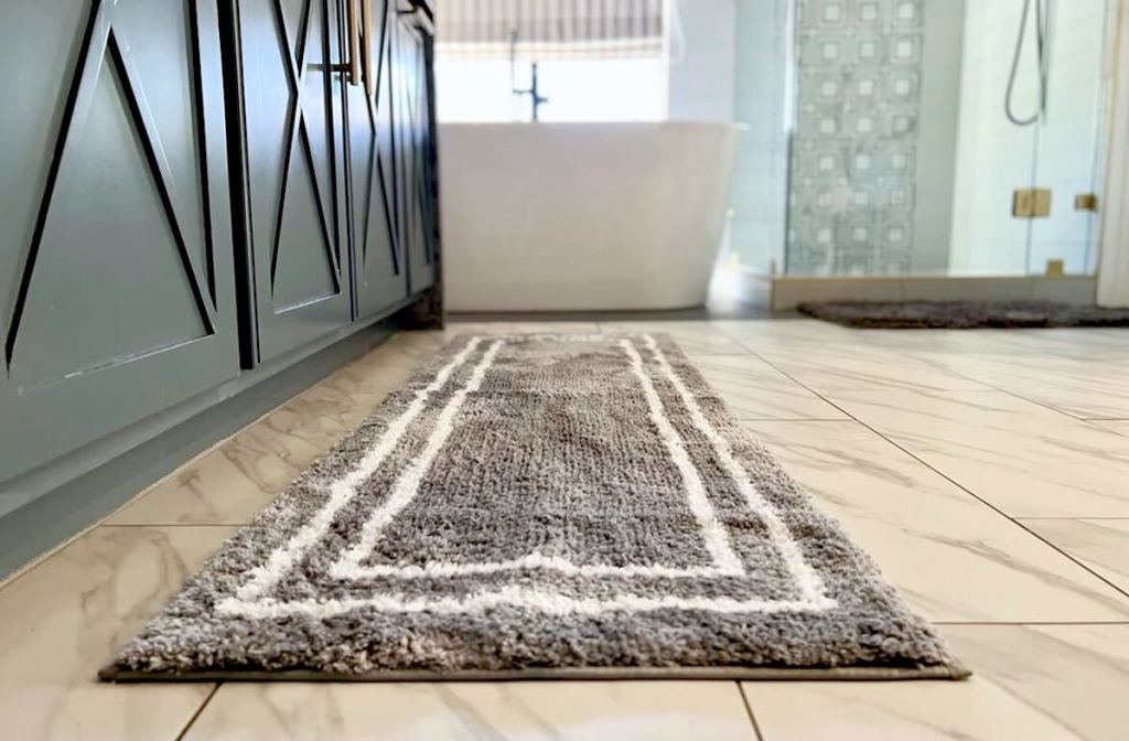 gray and white bath mat on bathroom floor