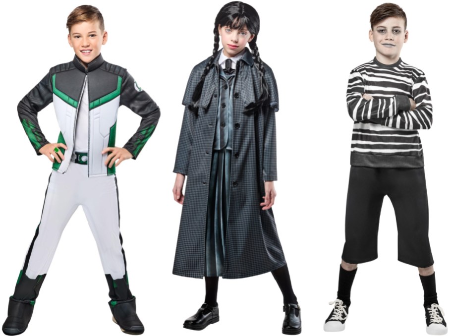 Three children modeling Halloween costumes side by side, featuring a green lantern costume on the left, a Wednesday Addams-style outfit in the middle, and a pugsley adams-style costume on the right.