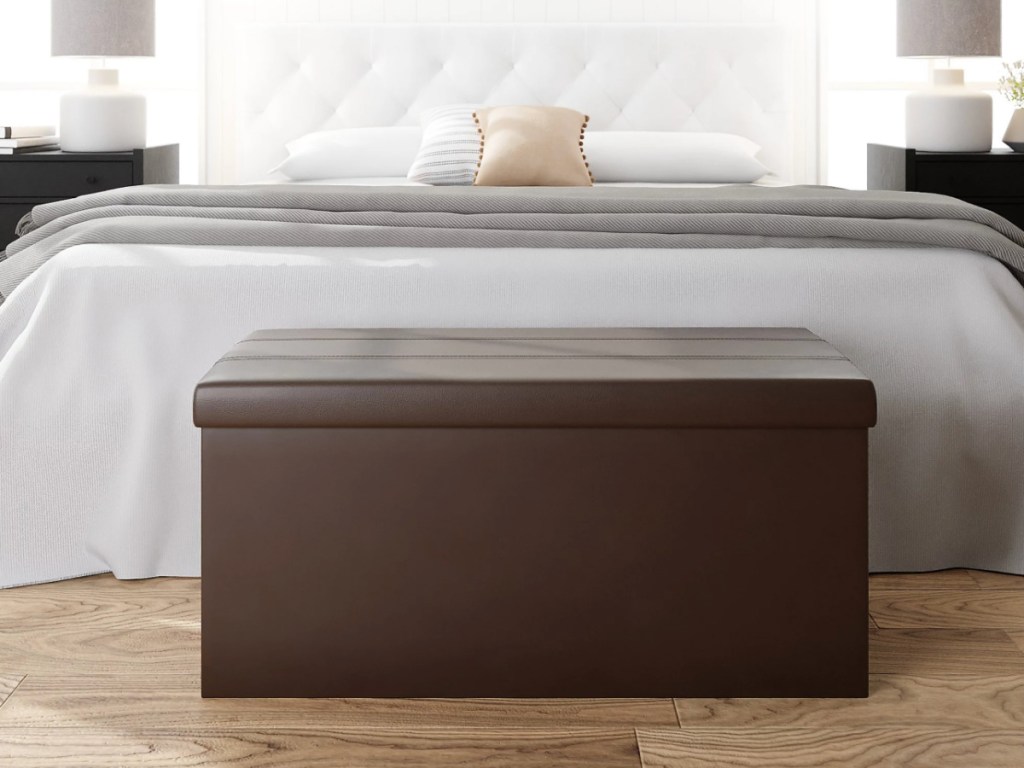 brown tufted storage ottoman at foot of bed