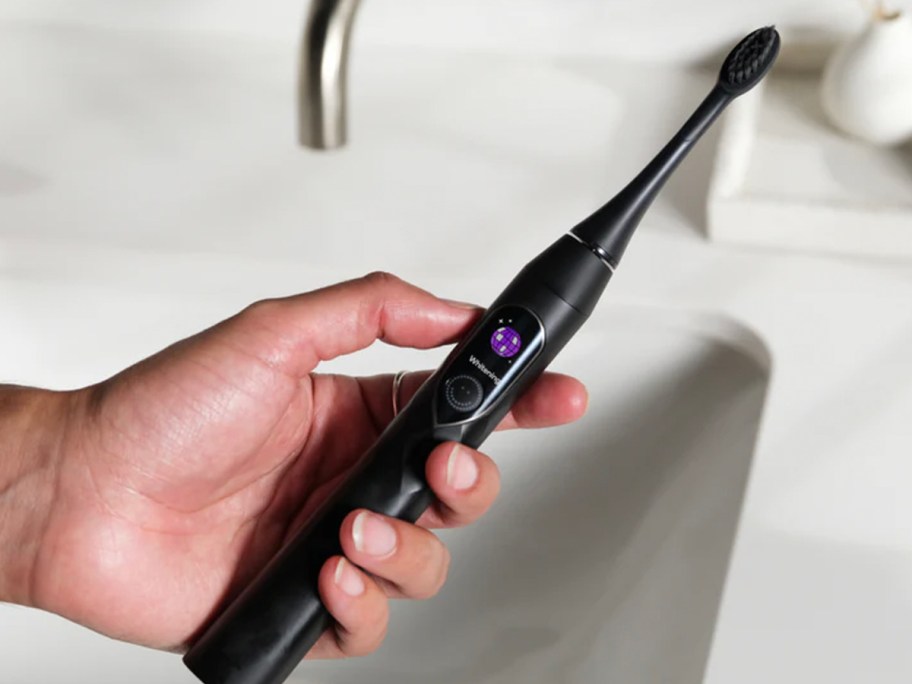 hand holding black toothbrush