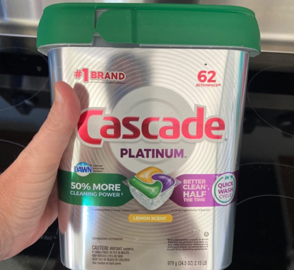 holding a bucket of Cascade dishwasher pods