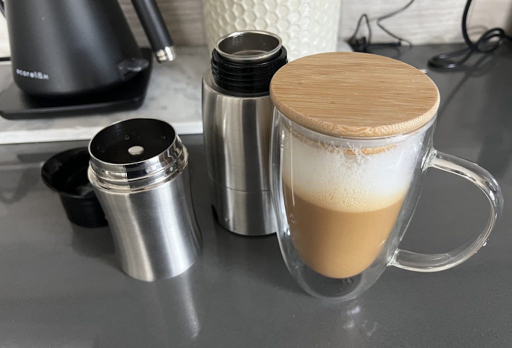 clear coffee mug with latte inside and bamboo lid