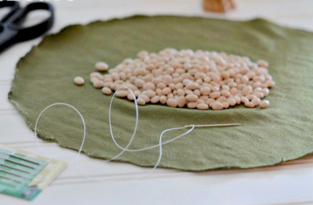 cloth circle with dry beans in the middle near sewing supplies