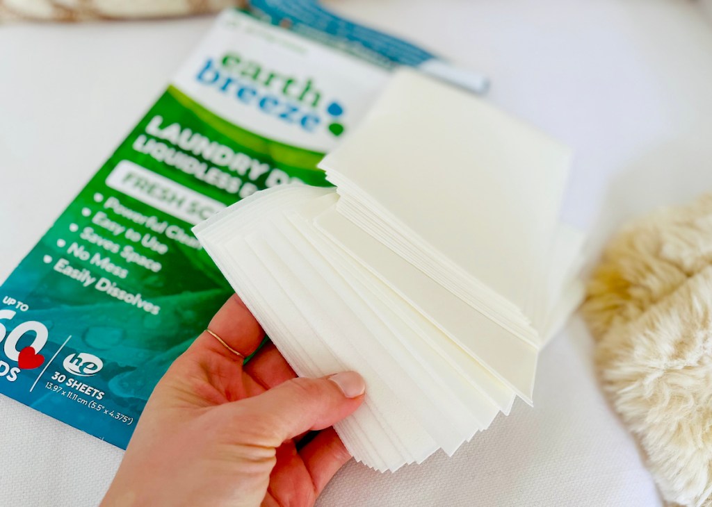 hand holding stack of earth breeze laundry detergent sheets