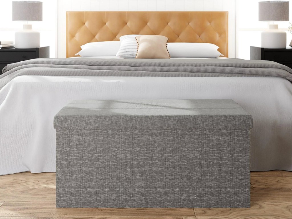 gray tufted storage ottoman at foot of bed