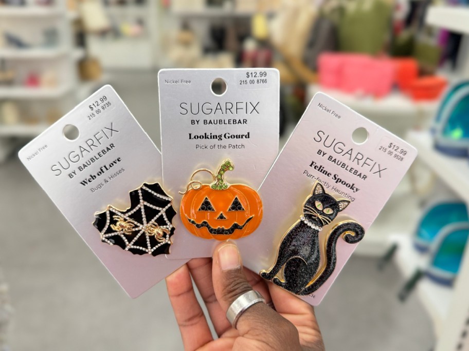 hand-holding-halloween-pins-in-hand أقراط SugarFix By Baublebar Halloween تبدأ من 13.99 دولارًا في Target | اختر من بين طن من الأنماط!