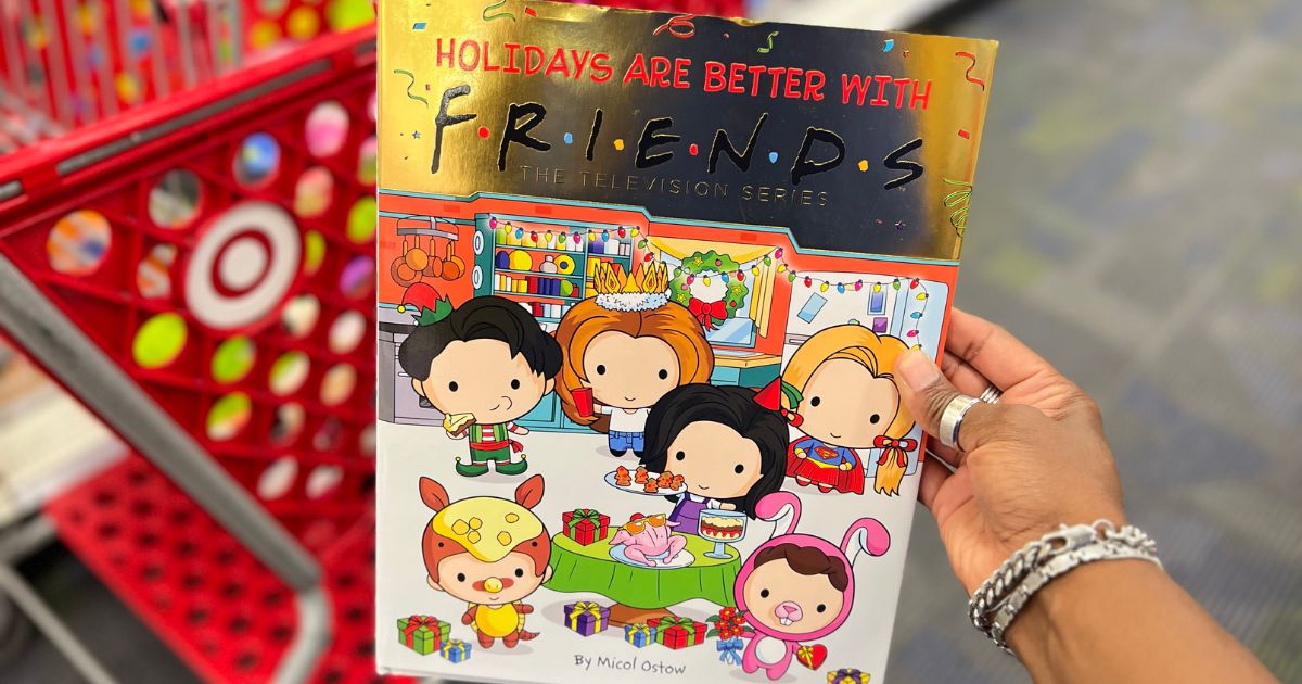 a womans hand holding a copy of the book holidays are better with friends