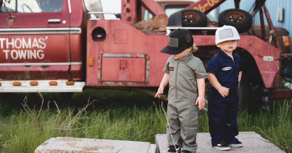 two kids near truck in coveralls