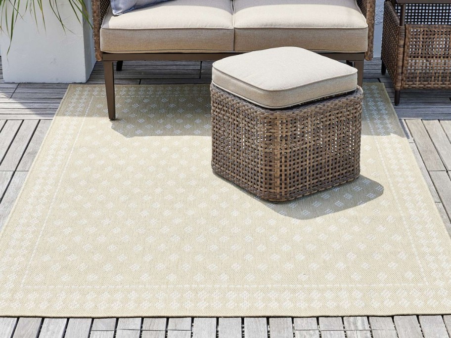 outdoor space with light tan and dotted diamond print rug and tan wicker furniture
