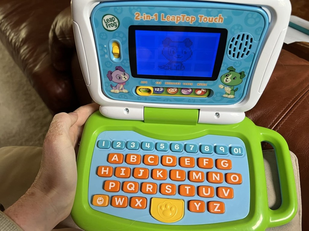 holding a child's toy laptop