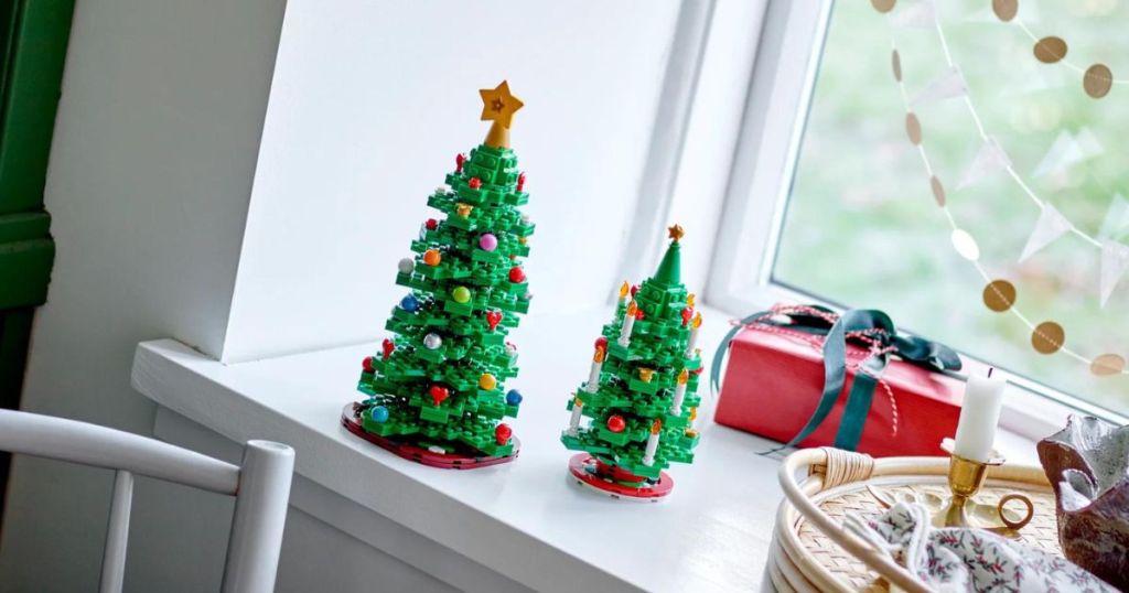 2 LEGO Christmas trees sitting by window