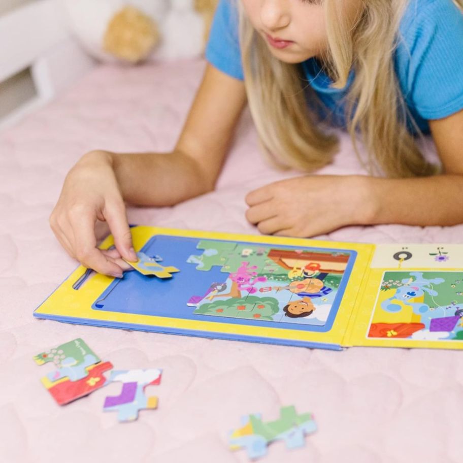 a llittle girl playing with a blues clues puzzle