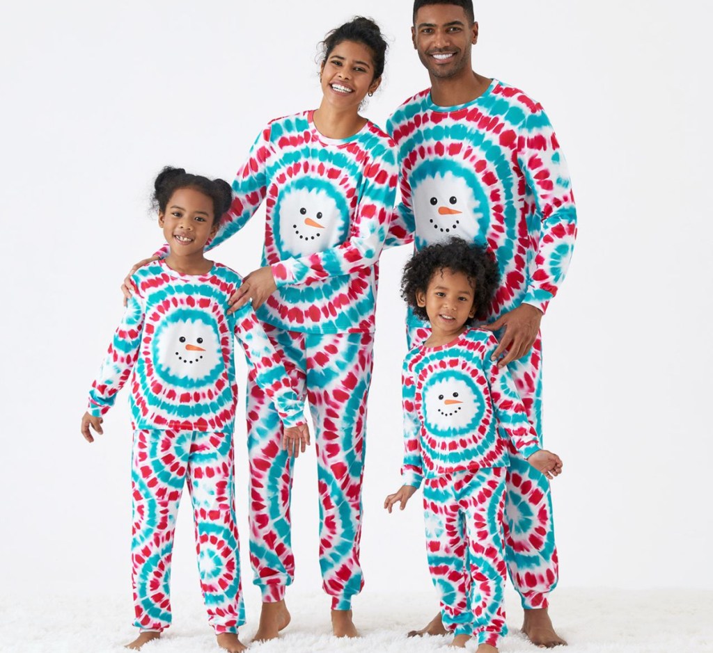 family standing in snowman print pajamas
