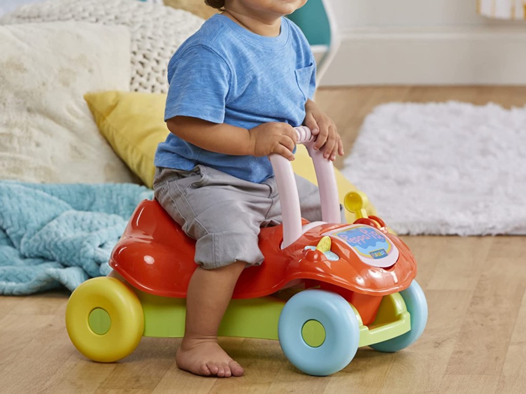child sitting on a peppa pig playskool ride on toy