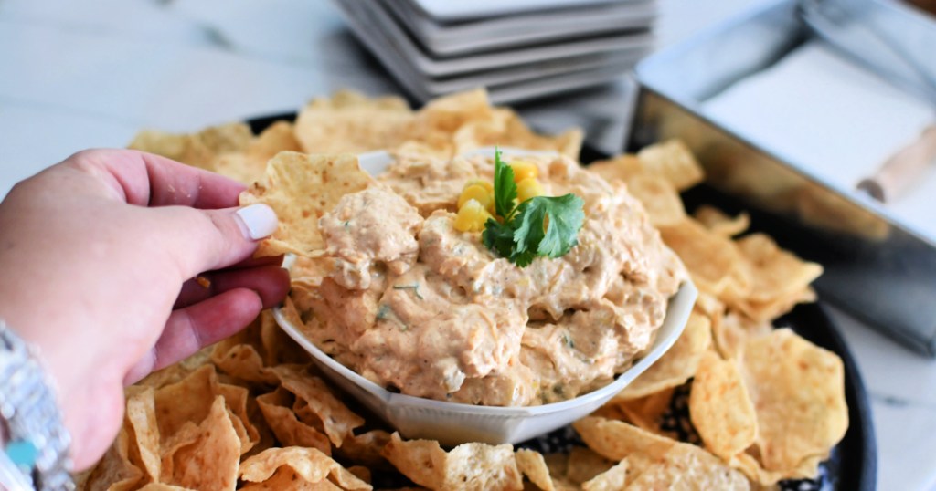 scooping corn dip with tortilla chip