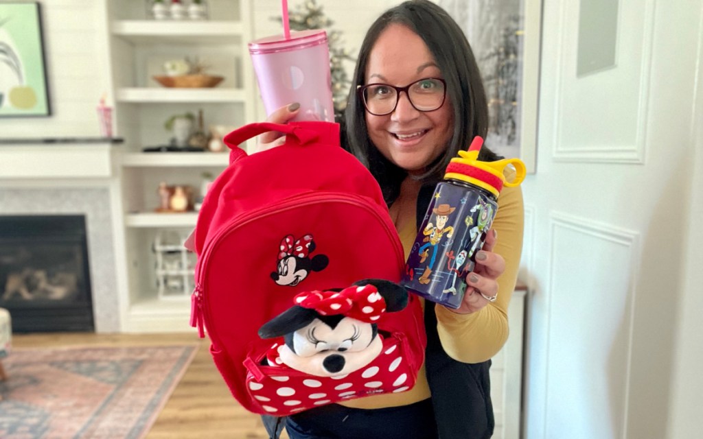 woman holding minnie backpack and tumblers