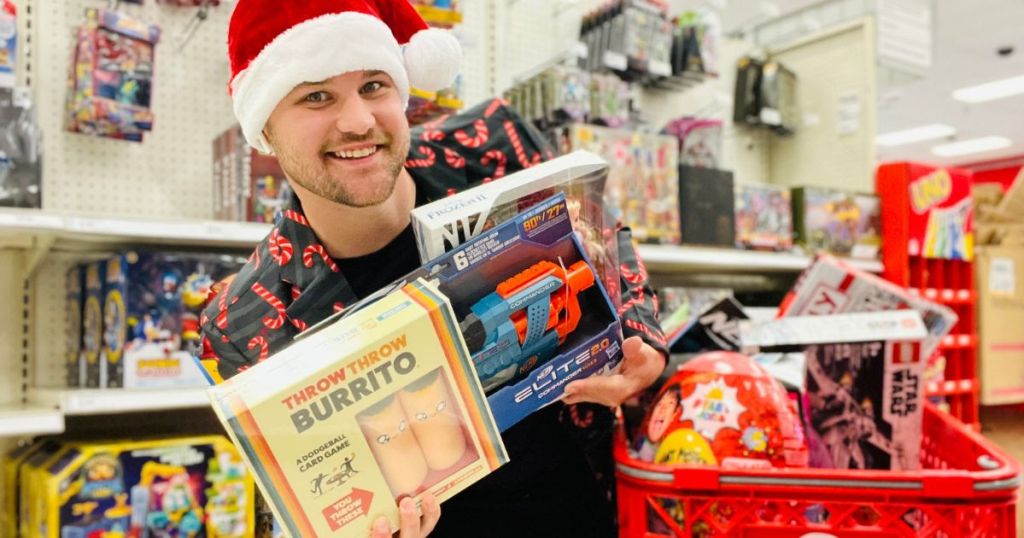  man in Santa hat holding games with Target shopping cart in background