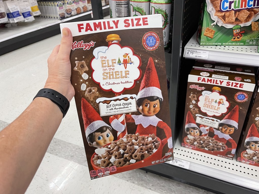 holding a box of Elf on the Shelf cereal