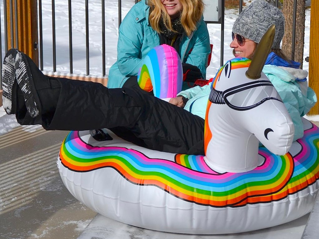 woman sitting on unicorn snow sled