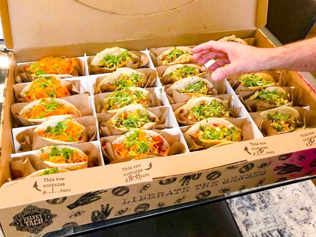 taking a taco from a box of 12