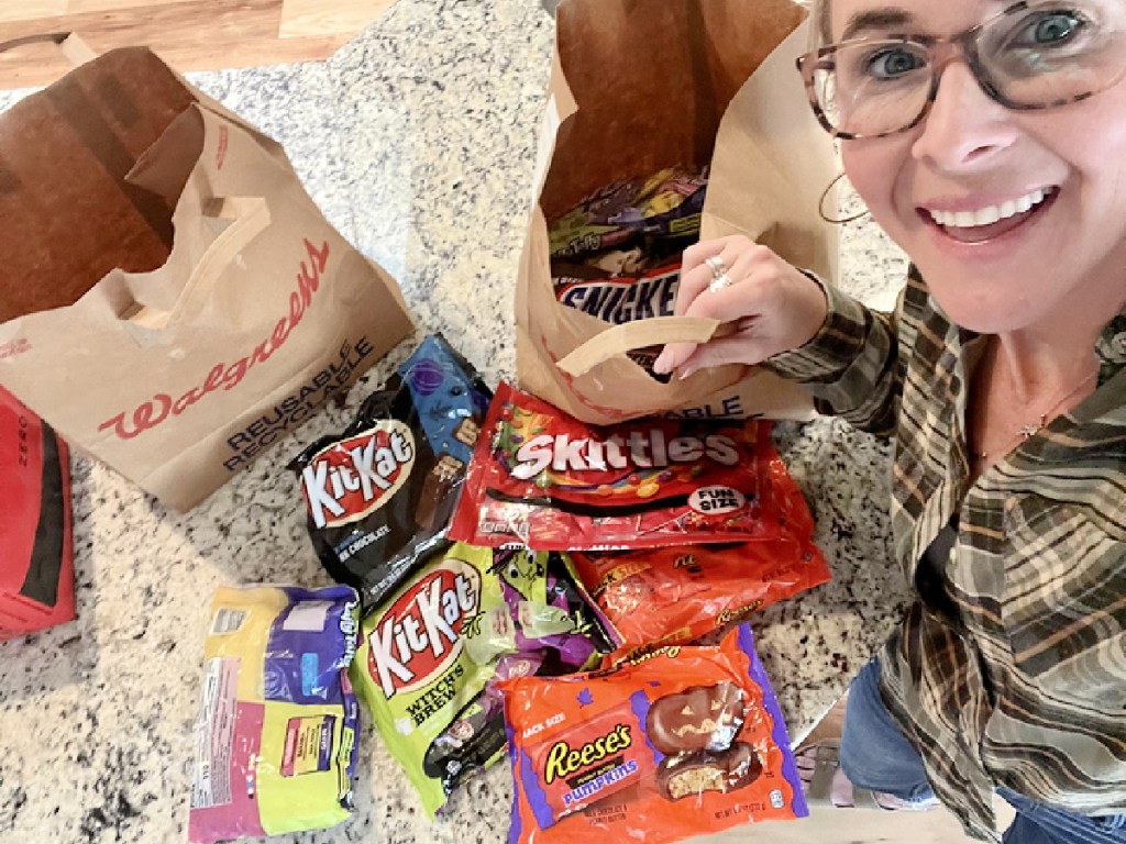 woman wearing glasses showing off halloween candy bags
