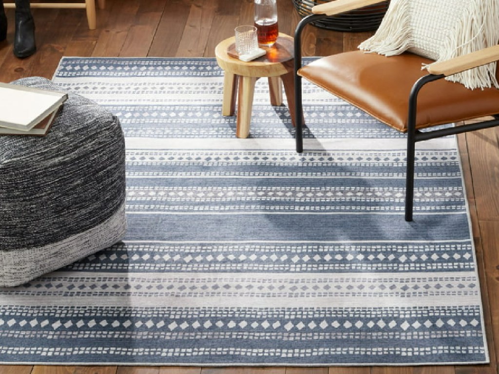washable stripe rug displayed in the living room with chair and pffer
