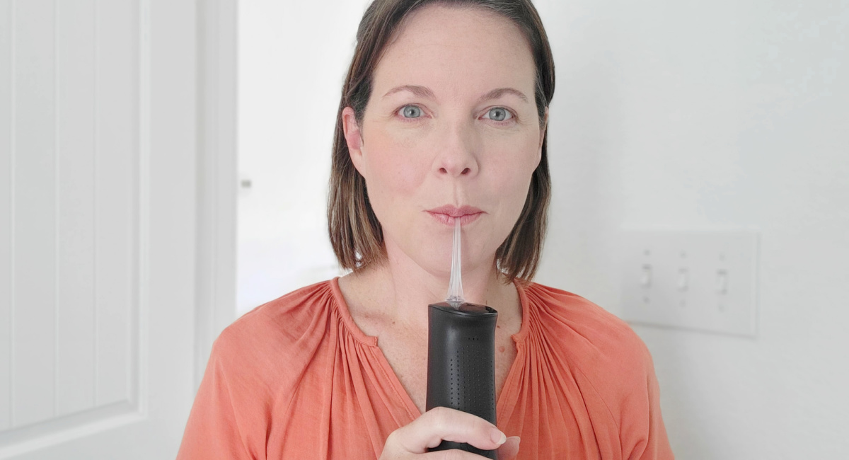 woman using water flosser