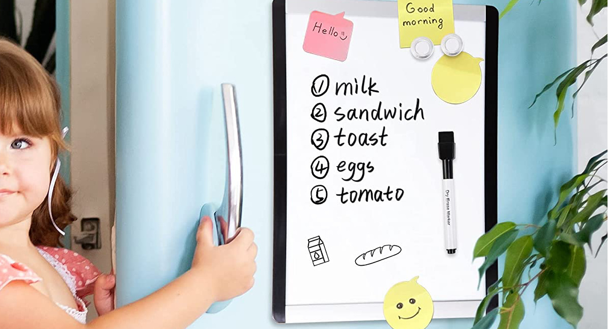 amazon basics dry erase whiteboard with note hanging on a fridge being opened by a young girl
