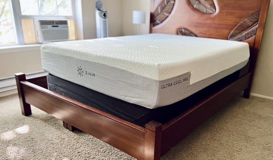 bare zinus ultra cooling gel mattress sitting on wood bed frame in carpeted bedroom