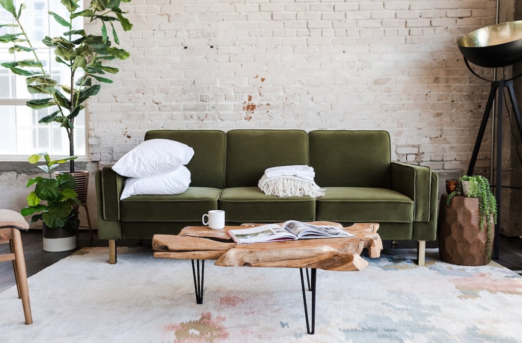 green velvet sleeper sofa in modern industrial room