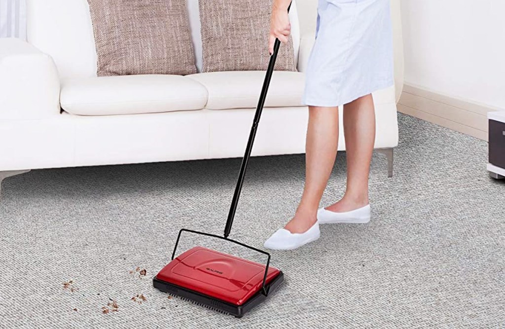 using red carpet sweeper on floor