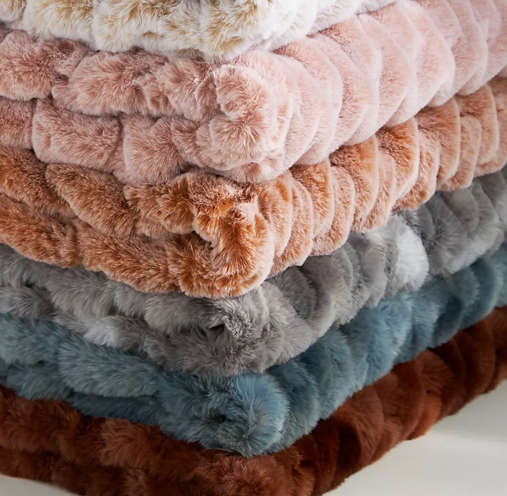 stack of folded faux fur throw blankets