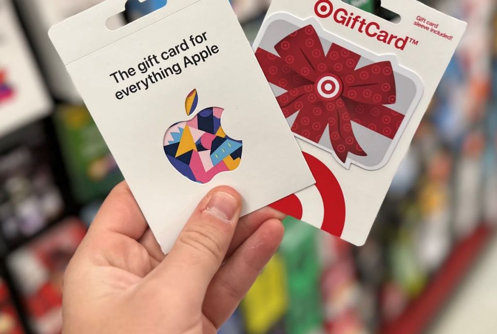 Hand holding an Apple and a Target gift card in the gift card section at Target.
