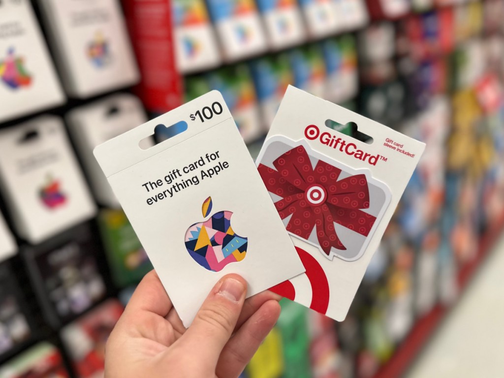 person holding up an Apple Gift Card and Target Gift Card in store