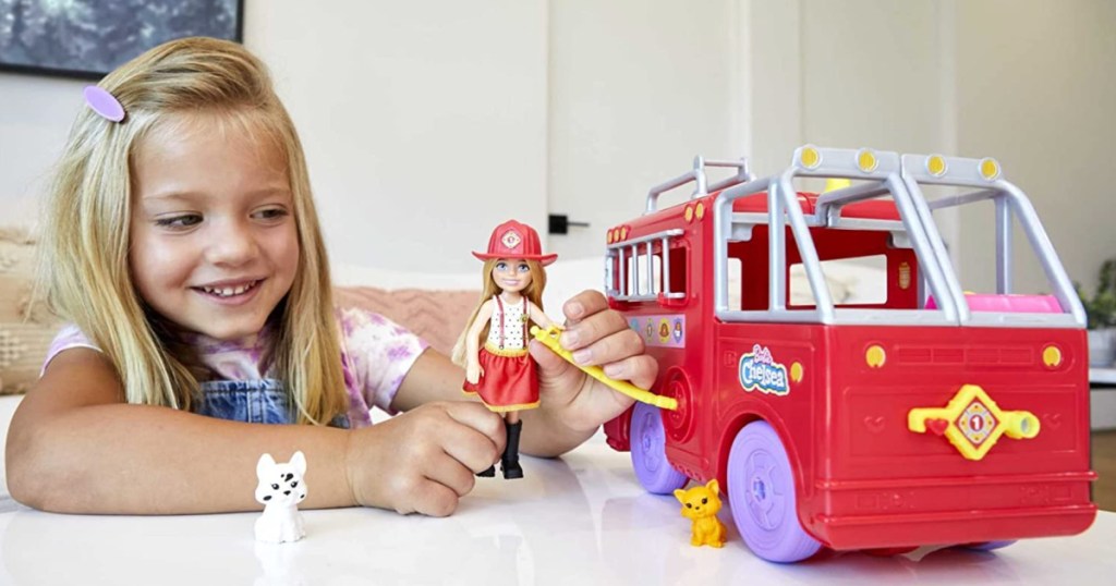 Little girl playing with Barbie Fire Truck