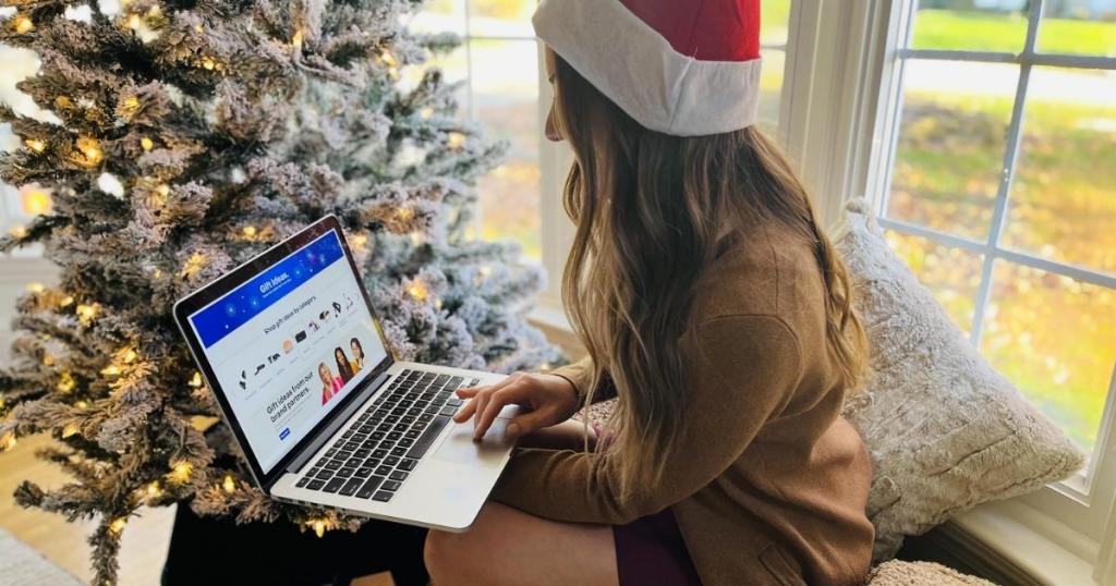 woman holding laptop with best buy gift guide on screen
