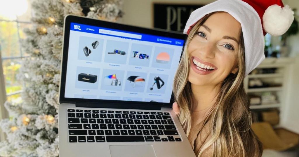 woman holding laptop with best buy gift guide on screen